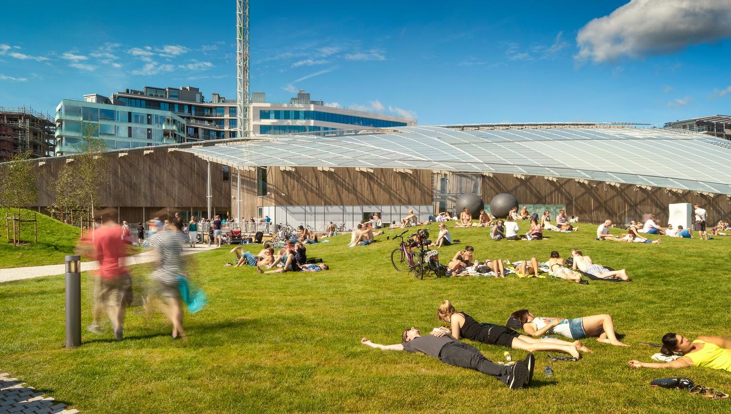 people relaxing in the grass in front of the Astrup Fearnley museum