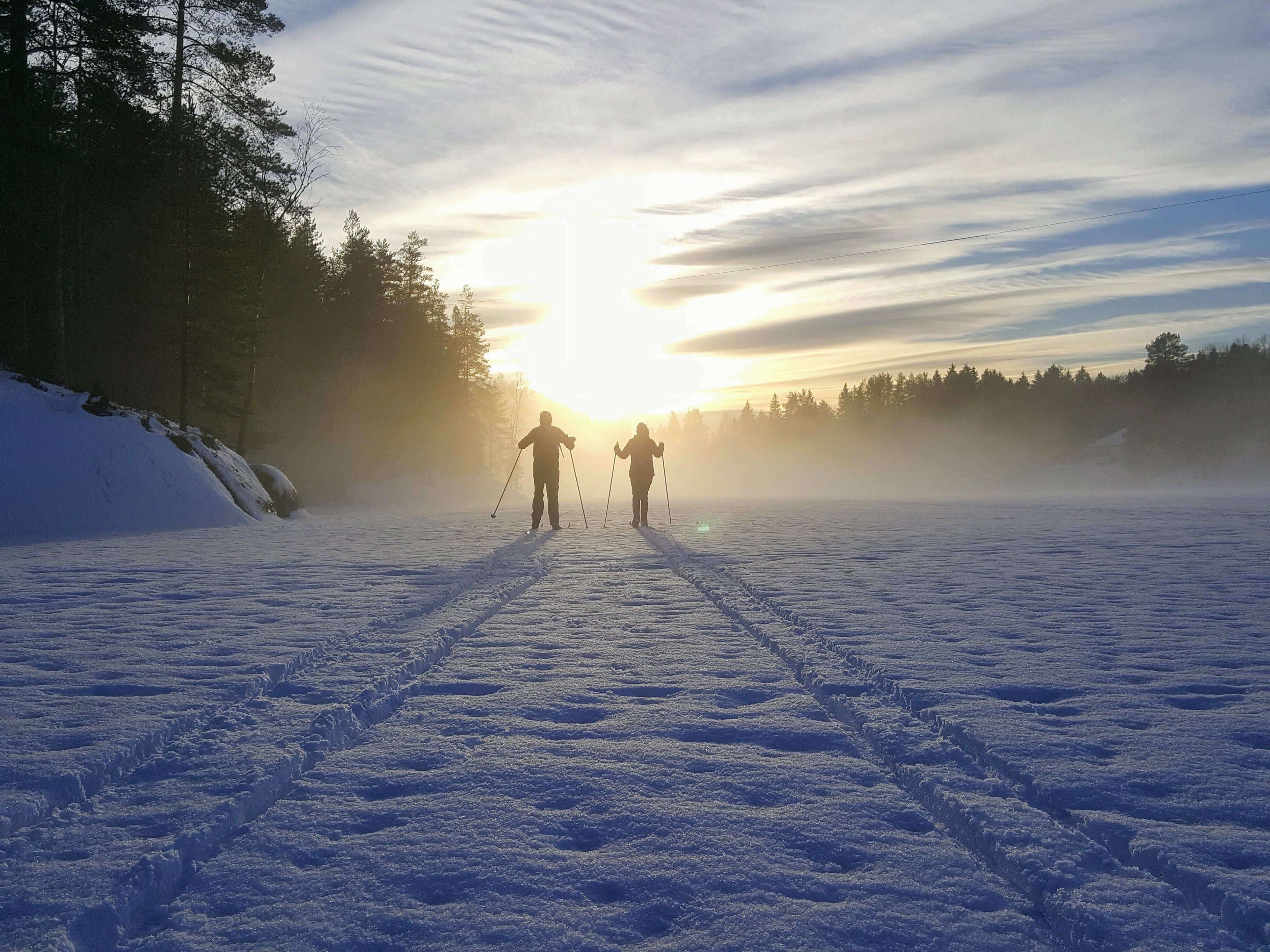 couple skiing into the sunset 
