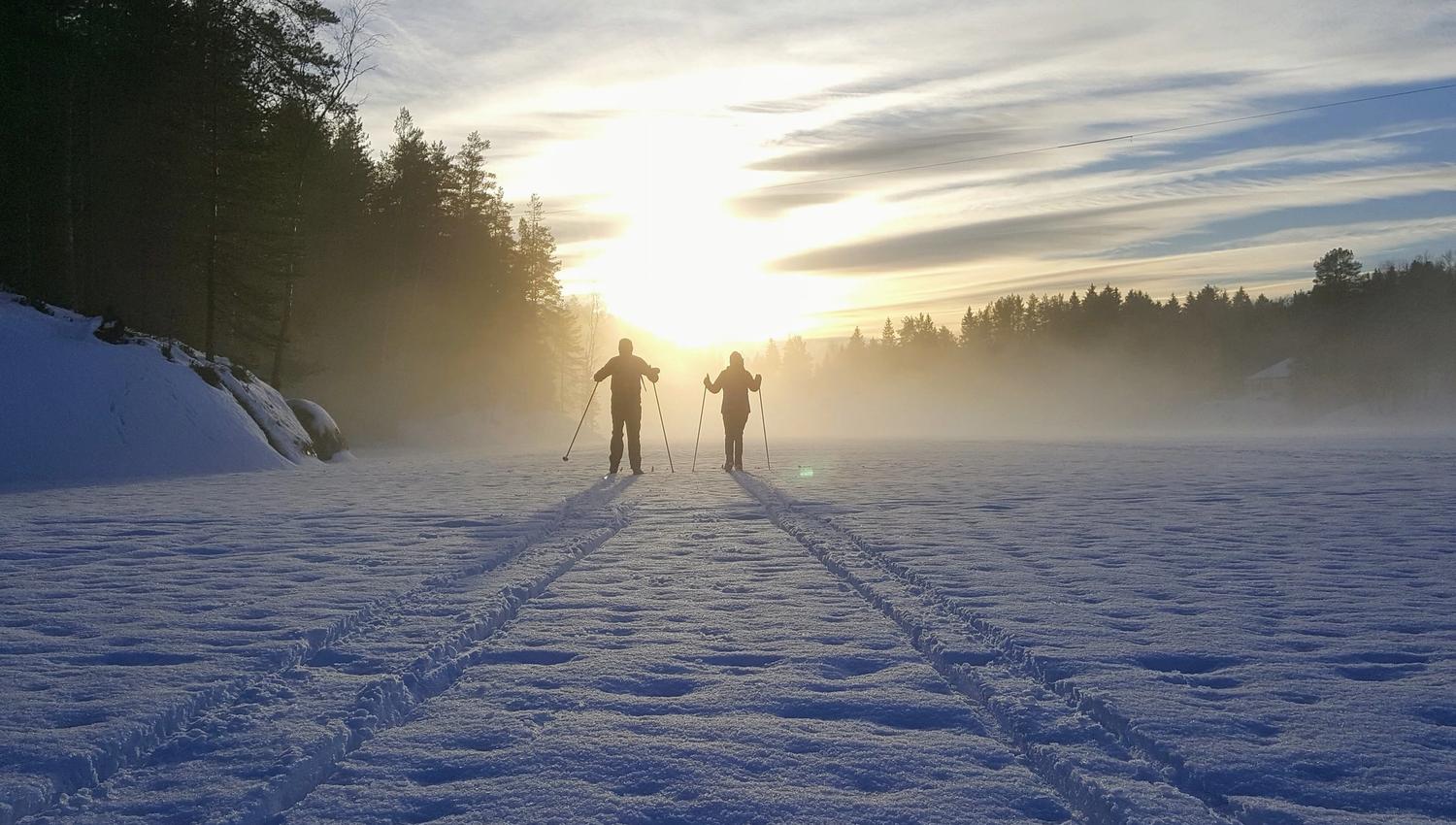 couple skiing into the sunset