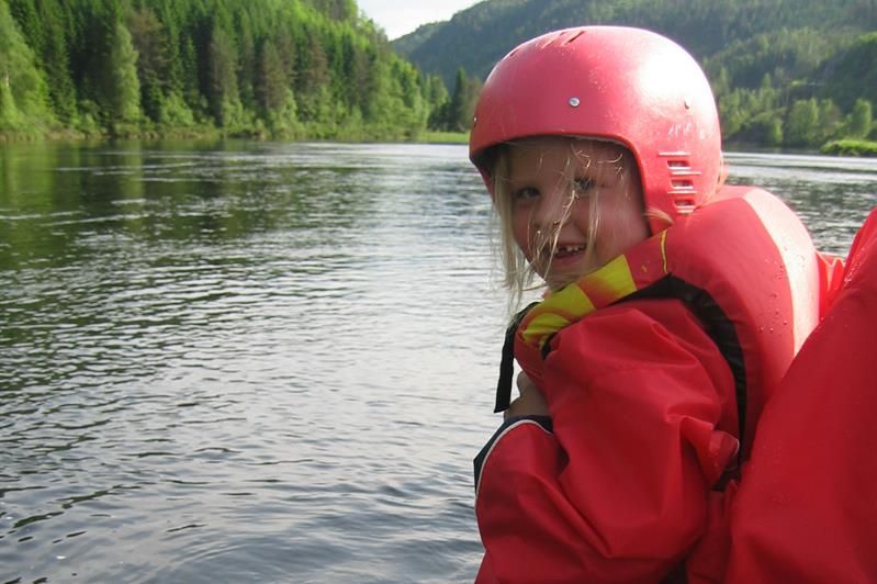 Lächelnde Kinder in roten Anzügen und roten Helmen