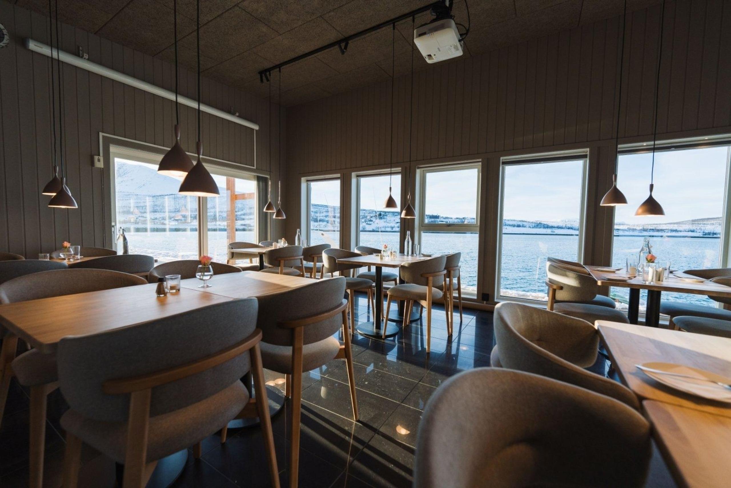 Restauranten Bøteriet med stoler og bord, panoramavinduer med utsikt til fjorden