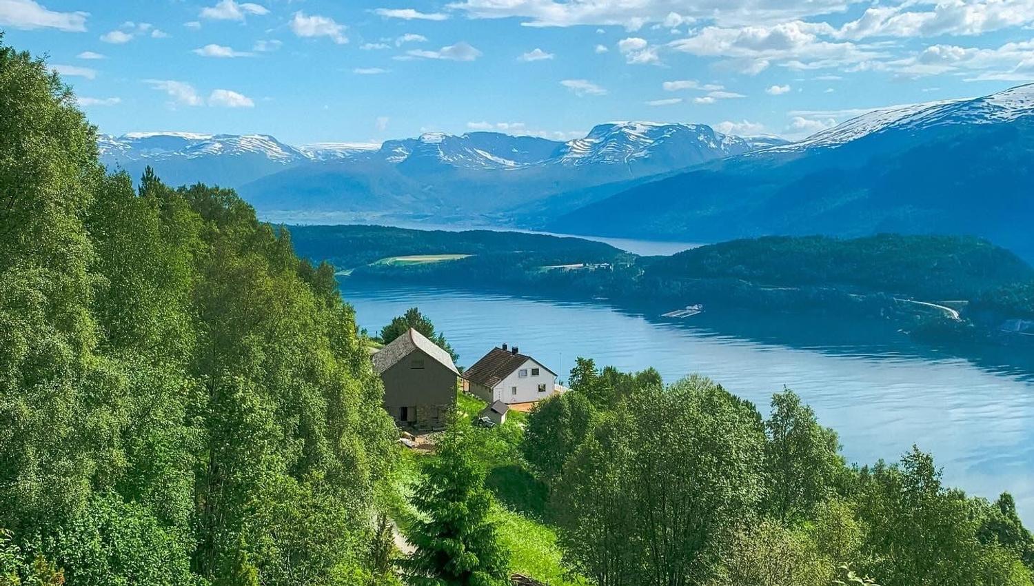 Stunning panoramic view from the Birdbox cabin at Skaara Living on Lotsberg in Nordfjord, surrounded by mountains and fjord landscape.