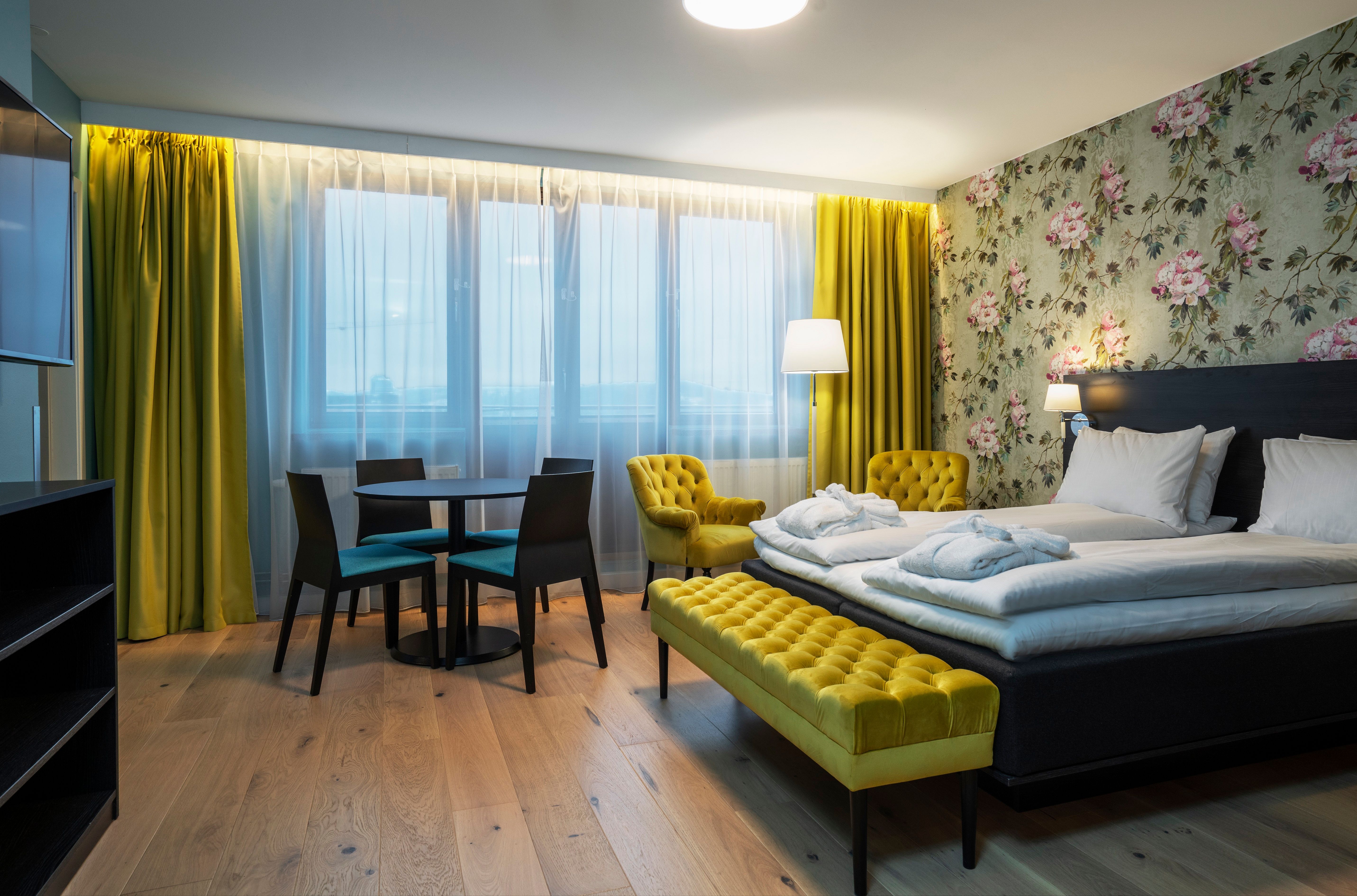 Room with double bed, Interior and curtains in yellow. Wooden floor. Thon Hotel Slottsparken, Oslo