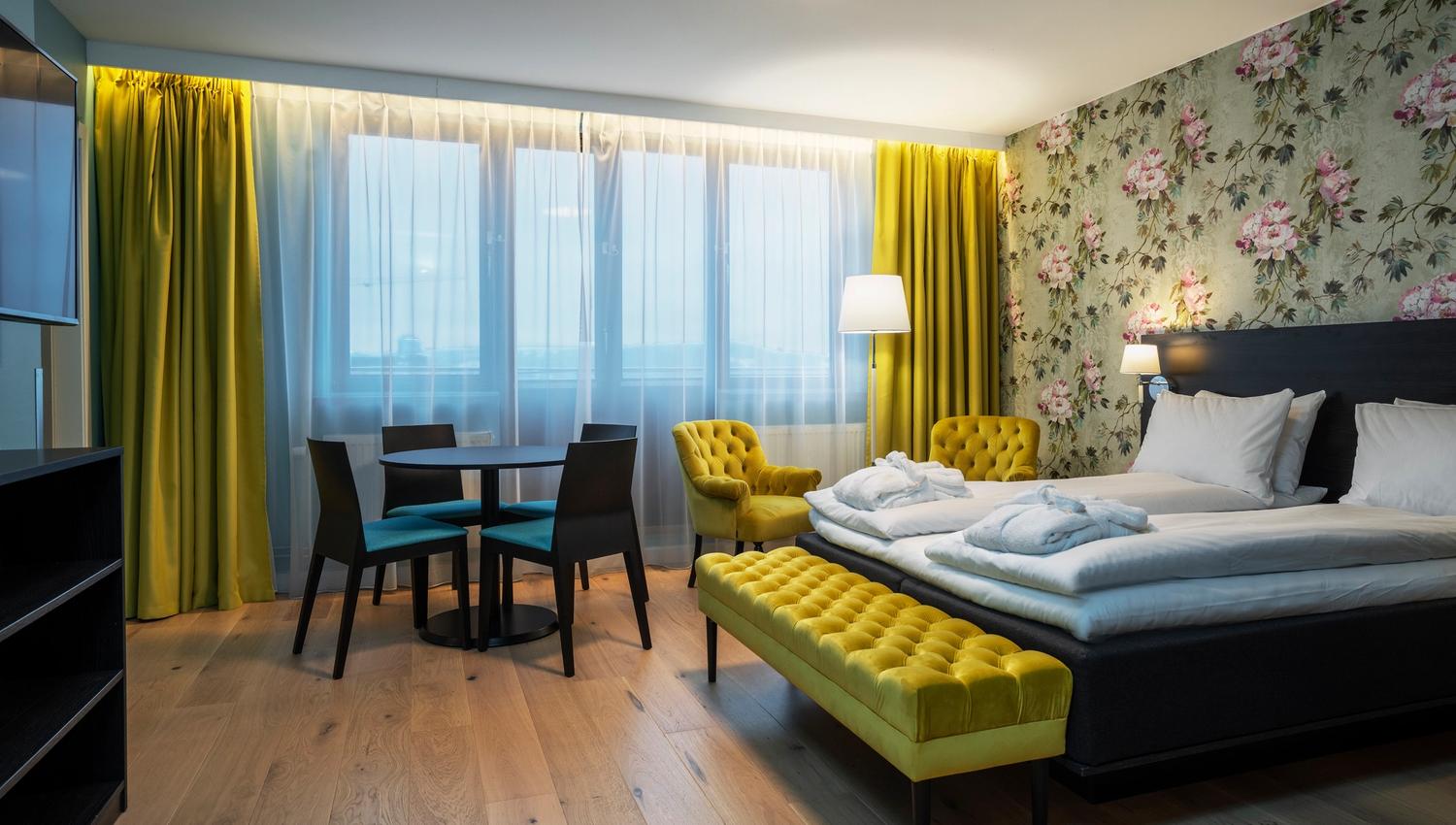 Room with double bed, Interior and curtains in yellow. Wooden floor. Thon Hotel Slottsparken, Oslo