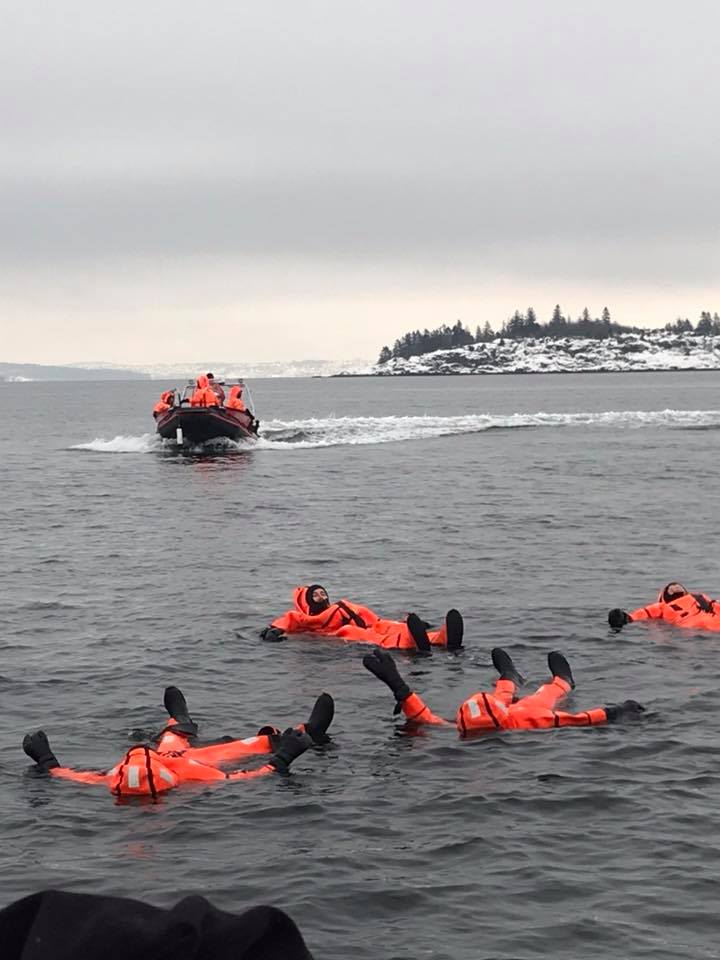 People in orange suits floating in the sea