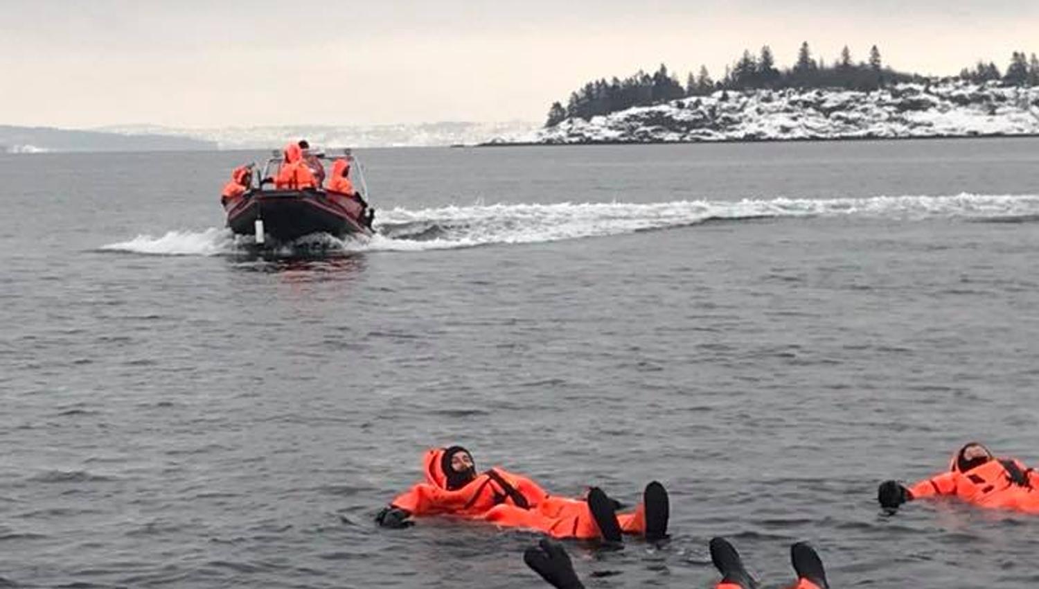 People in orange suits floating in the sea