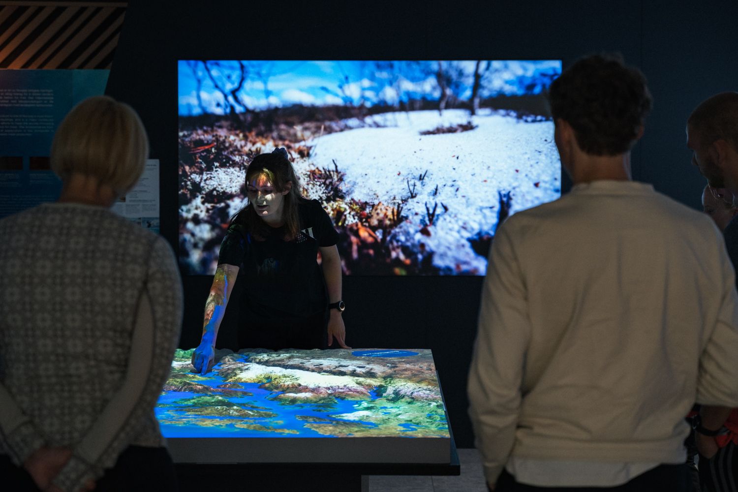 Guide pointing out key landscape features on the digital map in the “This is where we live” exhibition at Hardanger Aquaculture Centre.