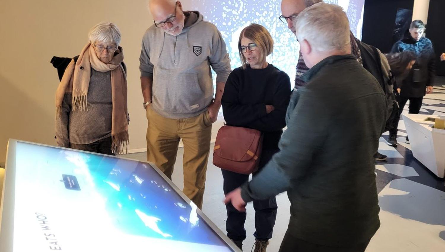 Guests engaged with one of the screens in the museum exhibition