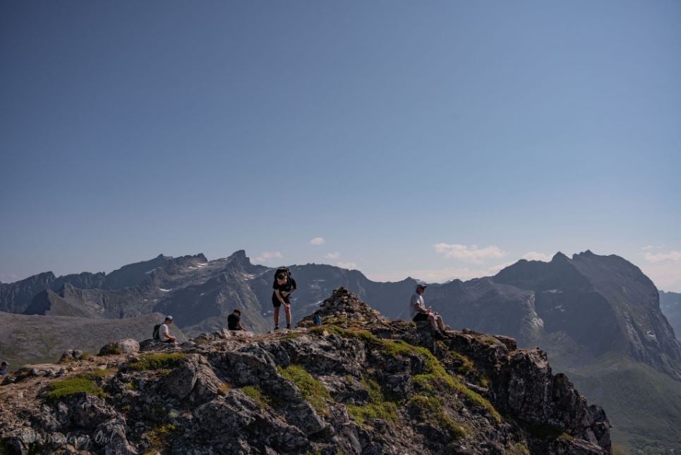Photo of guests on a mountain summit in summer