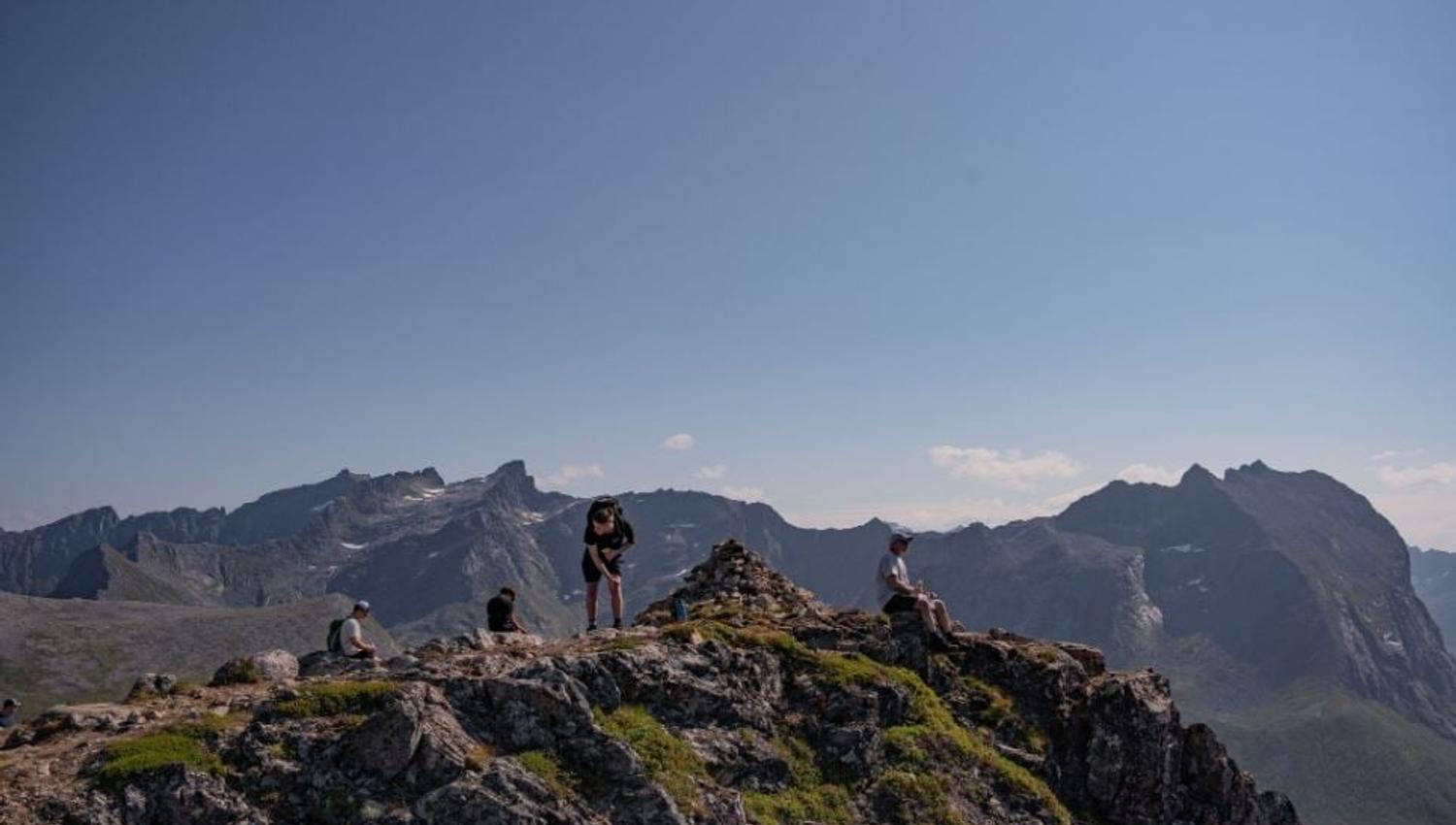 Photo of guests on a mountain summit in summer