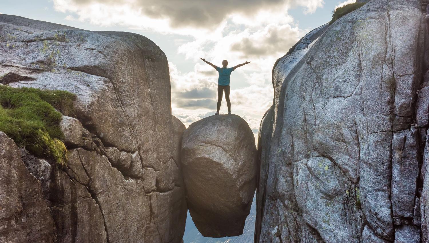 High above the fjord, the Kjeragbolten boulder is wedged between the rock walls