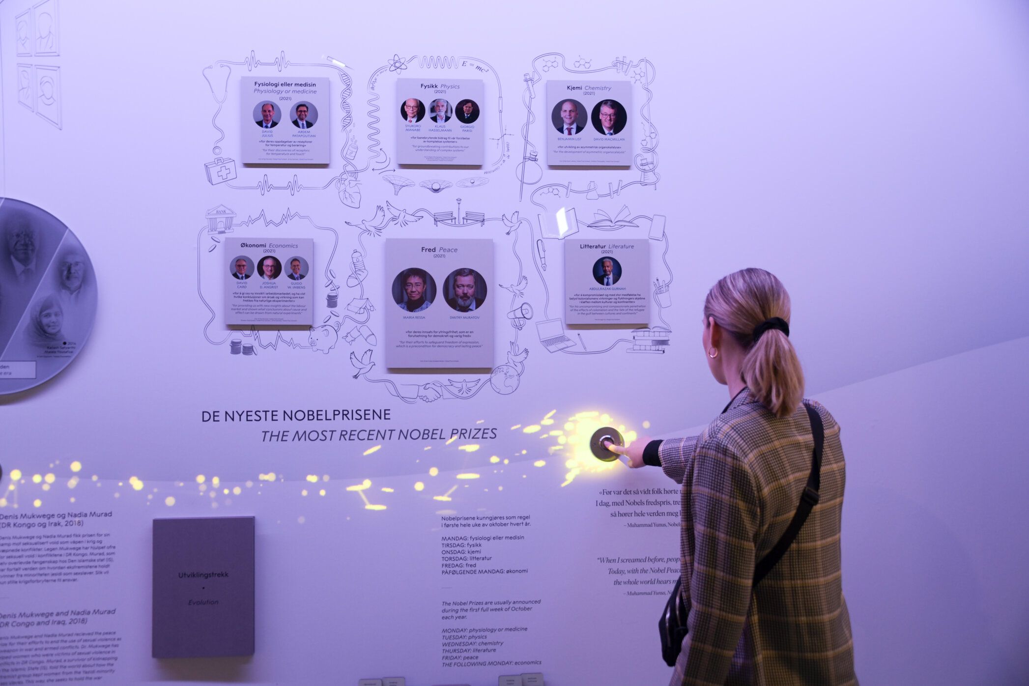 Purple room with pictures and a girl facing the wall and pushing a button.