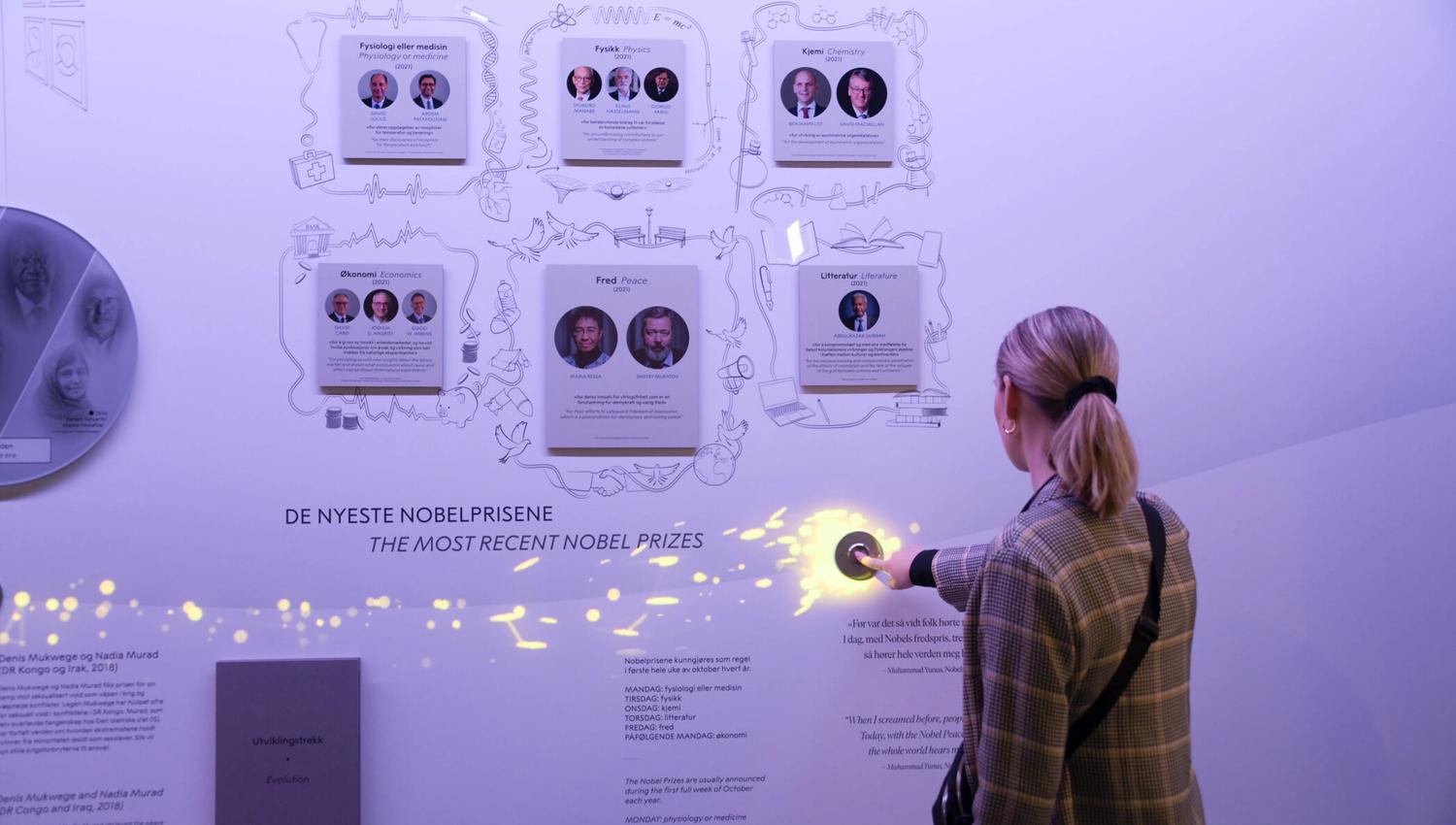 Purple room with pictures and a girl facing the wall and pushing a button.