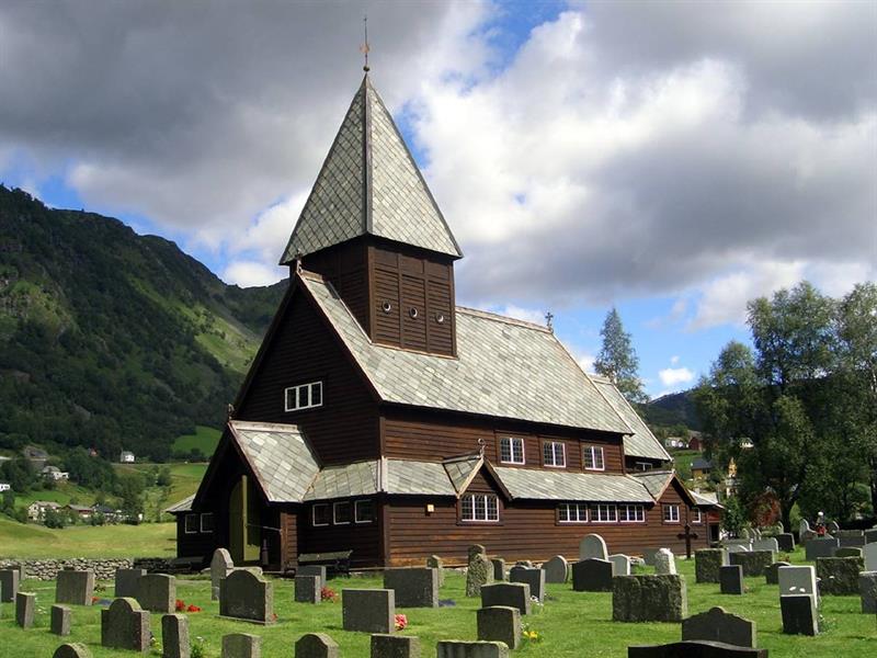 Front view of Røldal Stave Church with traditional Norwegian timber design and scenic surroundings.
