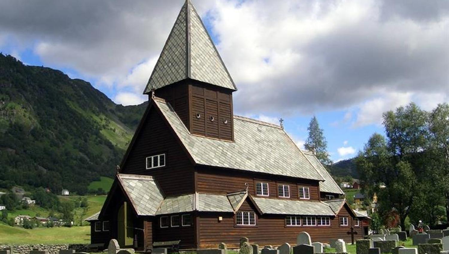 Front view of Røldal Stave Church with traditional Norwegian timber design and scenic surroundings.