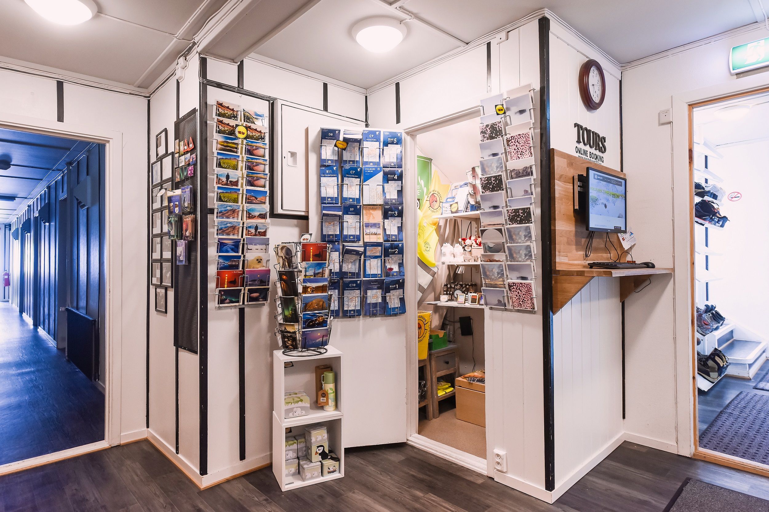 Souvenirs, maps and other wares on shelves in the reception at the guesthouse