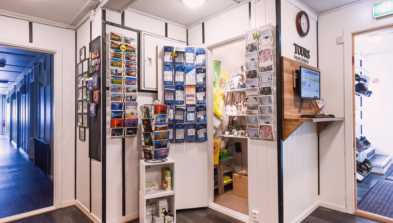 Souvenirs, maps and other wares on shelves in the reception at the guesthouse