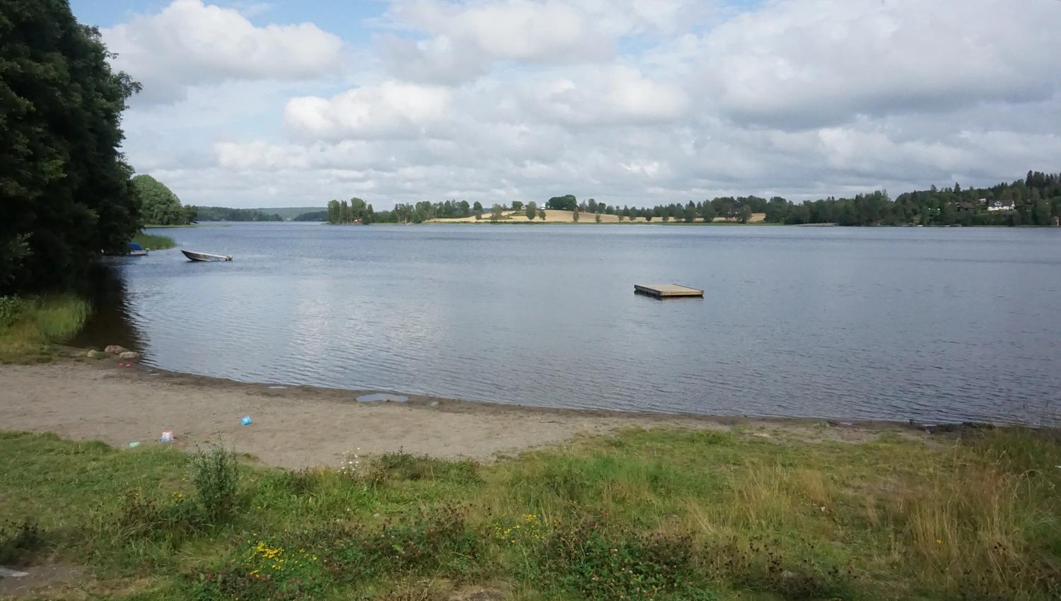 Strand med badebrygge i vannet