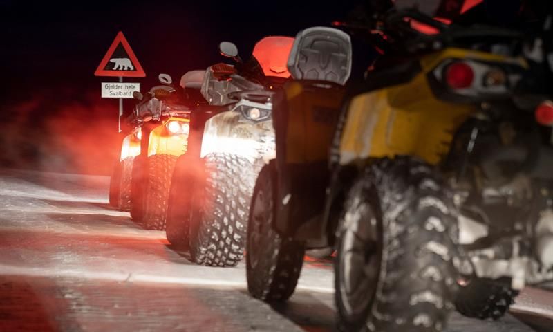 Tre ATVer stående på rekke foran isbjørnskiltet