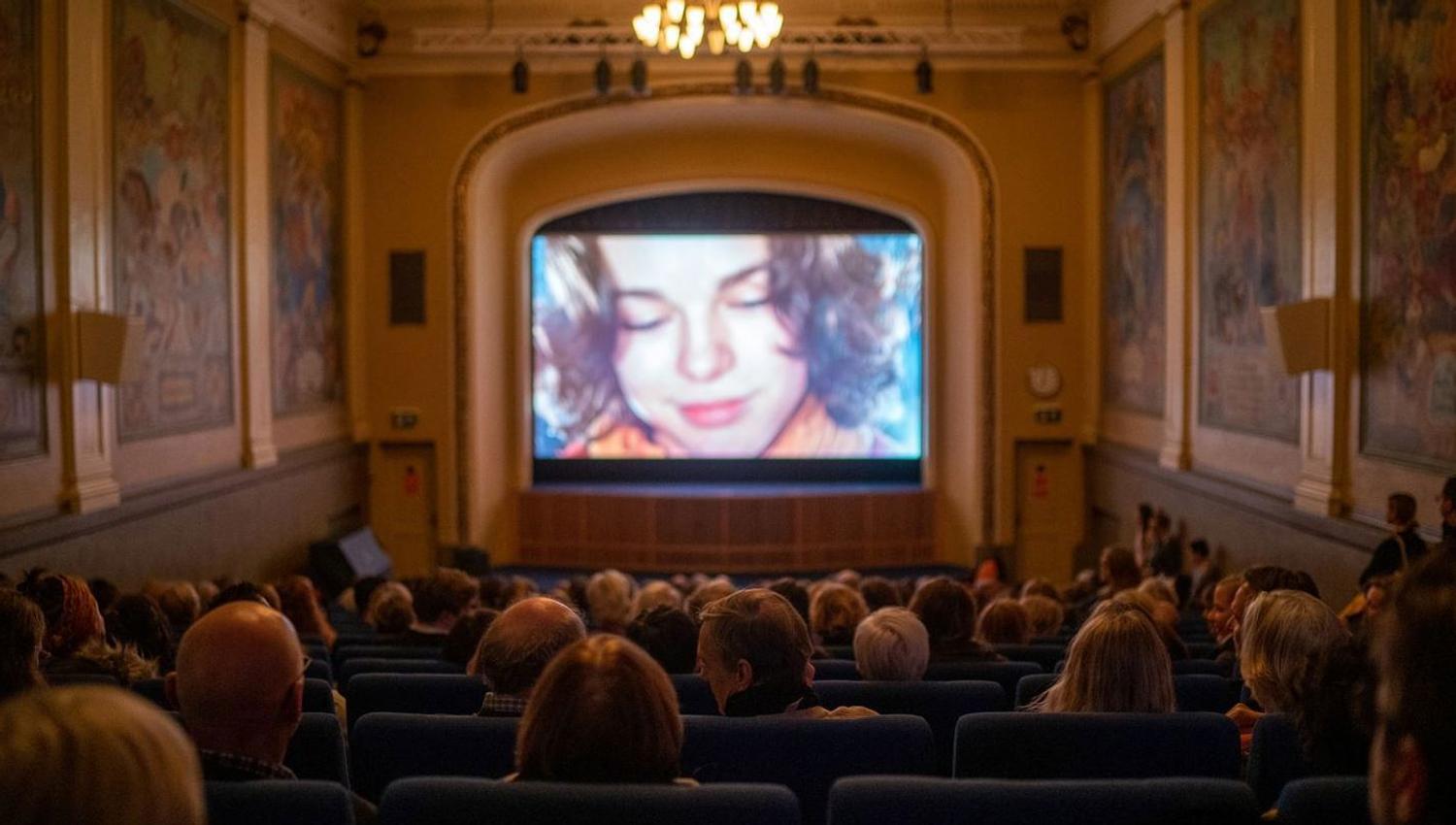 Gjester som ser på en film i en kinosal