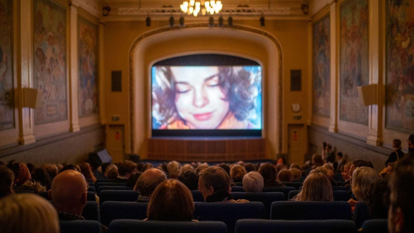 Gjester som ser på en film i en kinosal
