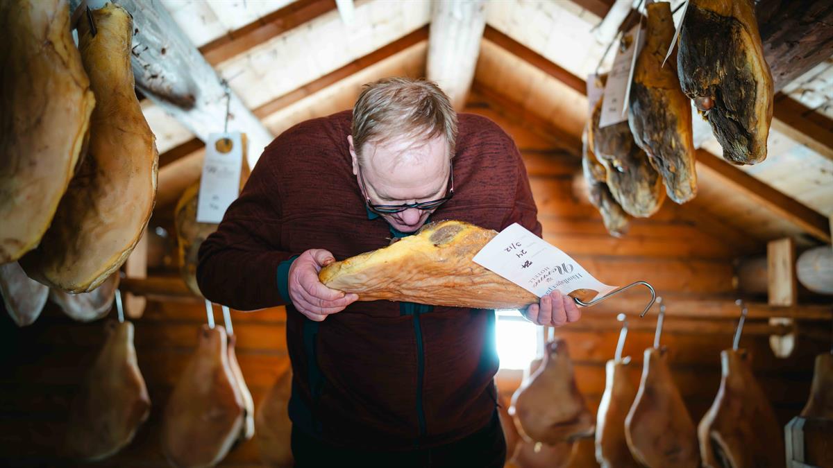 Hotellverten sjekker modningen på spekeskinkene