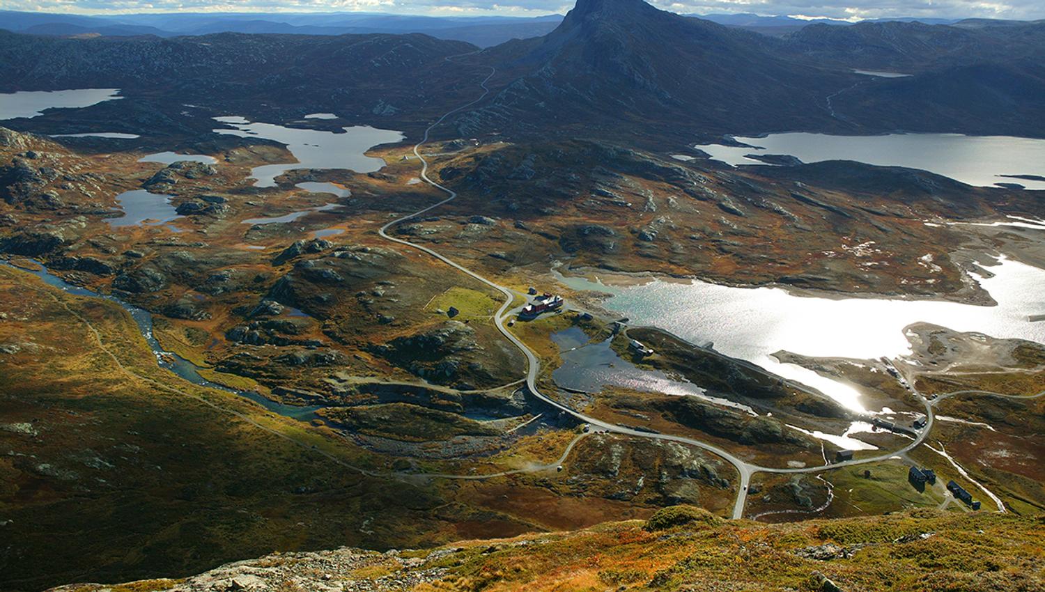 Breathtaking view from Synshorn towards Bygdin, Bitihorn and many small lakes. The National Tourist Route Valdresflye winds through the rugged mountai