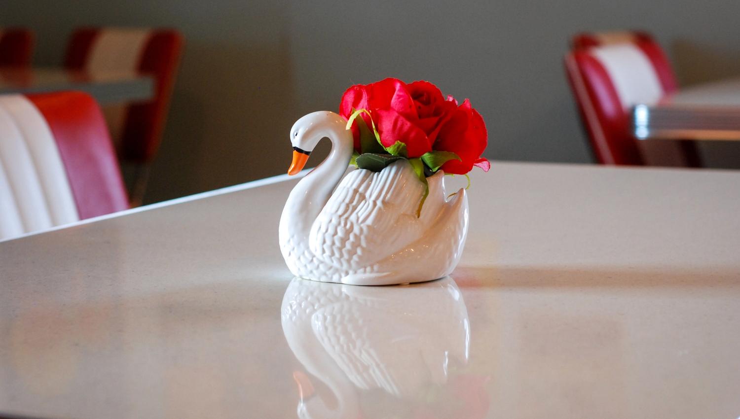 A swan made of glas with a red rose