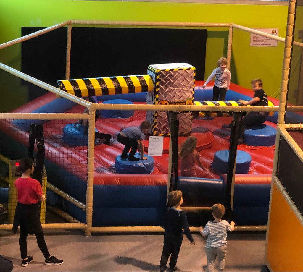 Wipeout, an activity for slightly older children aged 6 and over. Here the children have to duck when the pole arrives. We see four children at play.
