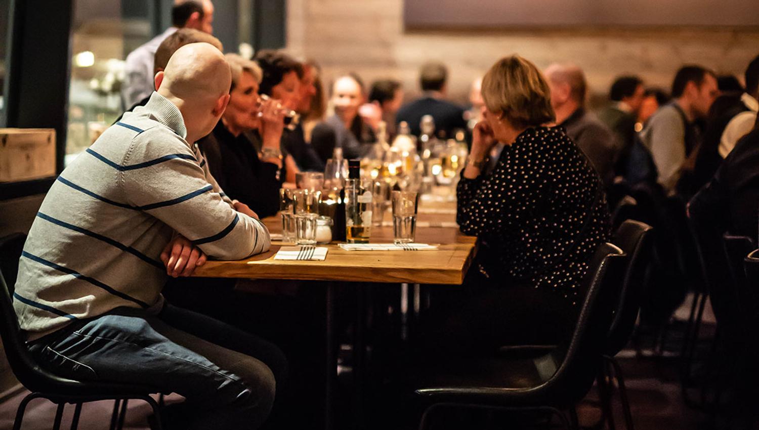 Stemningsfull inneservering - folk koser seg med mat og drikke