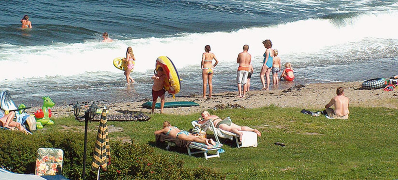Badegjester på stranden, bølge