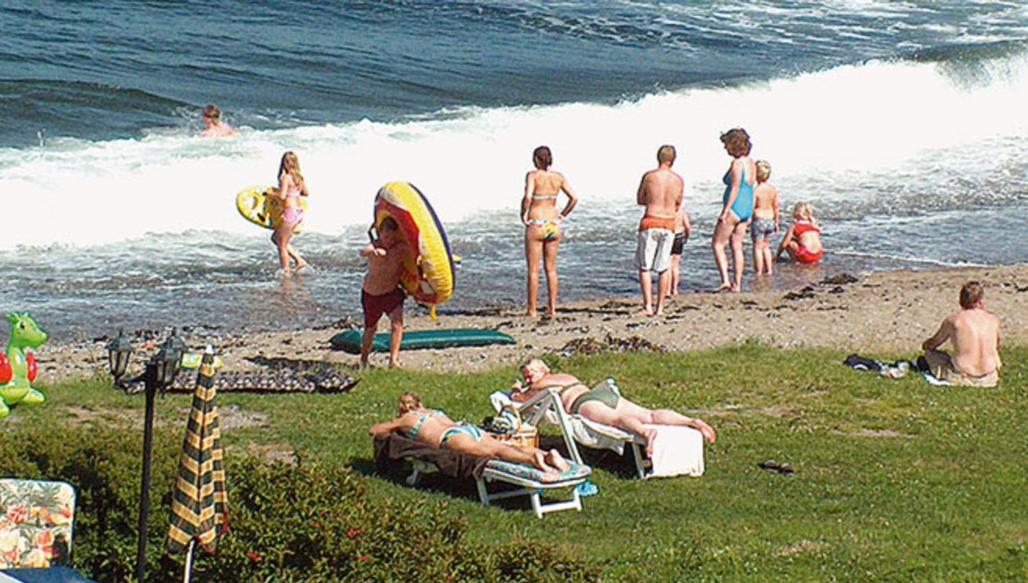Badegjester på stranden, bølge