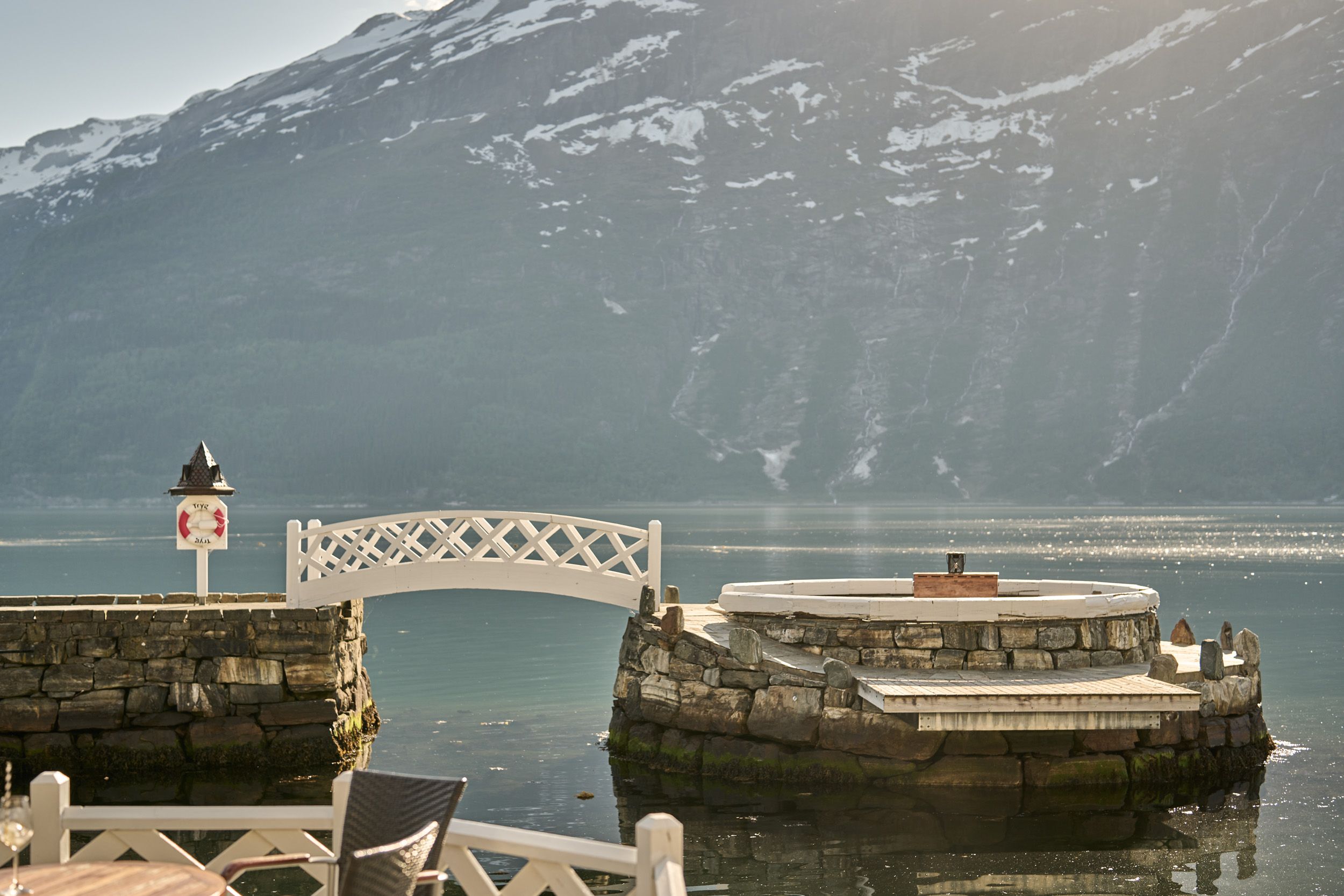 Exclusive sitting area by the fjord, surrounded by stonework and stunning scenery.
