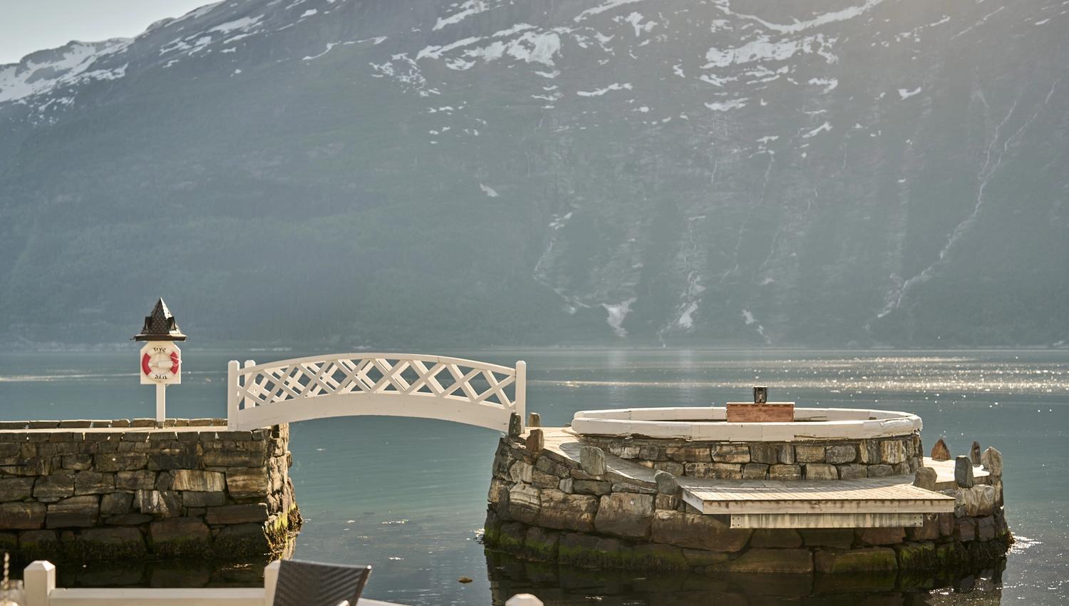 Exclusive sitting area by the fjord, surrounded by stonework and stunning scenery.