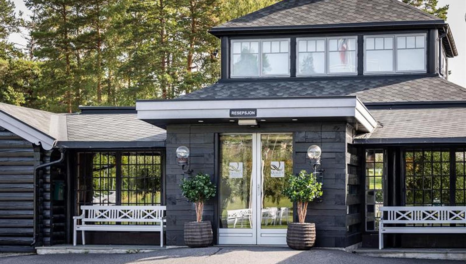 Inngangsparti med mørke vegger og hvite detaljer