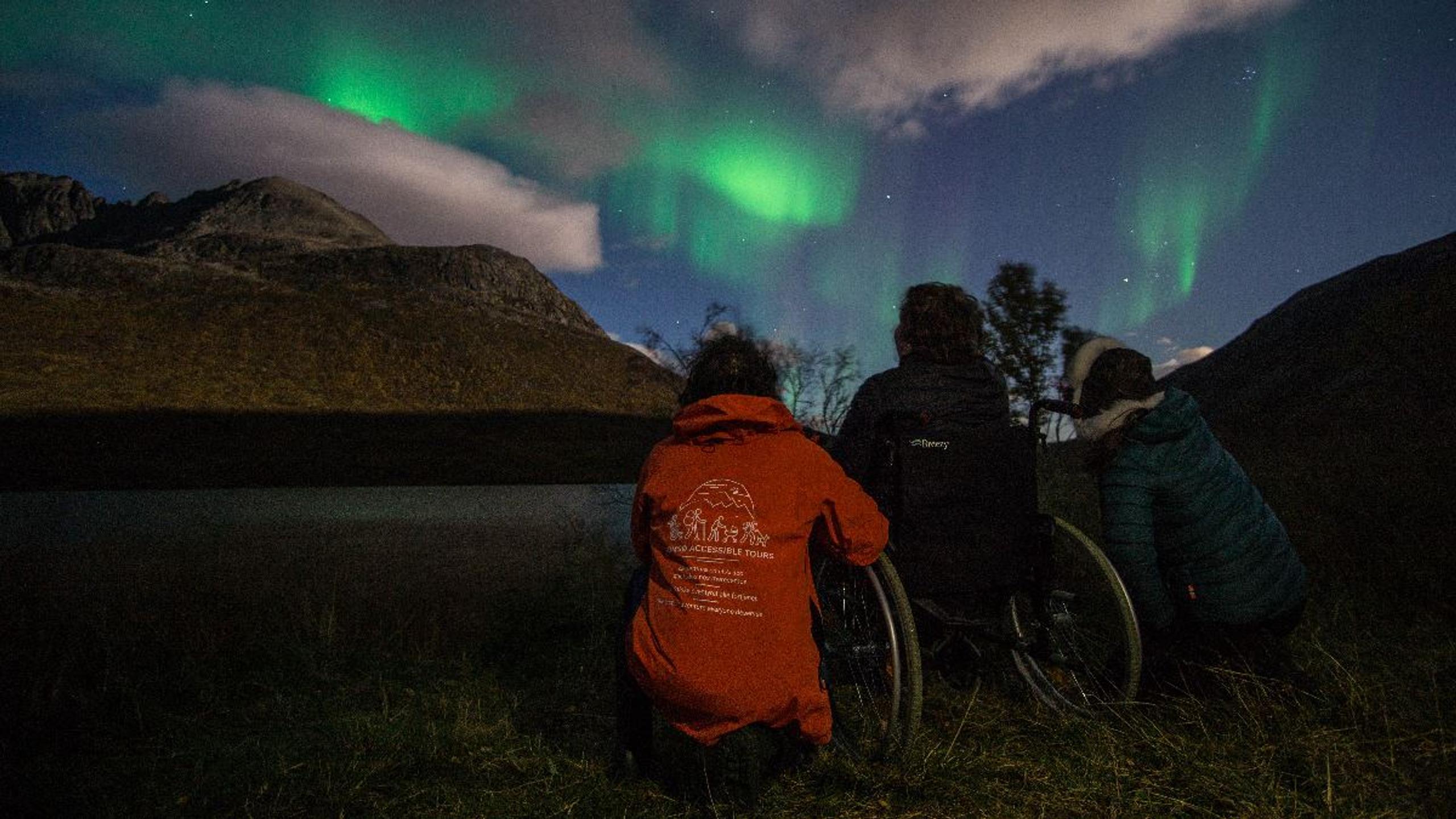 Guests experience the Northern Lights on an accessible guided tour from Tromsø in the Arctic winter landscape.