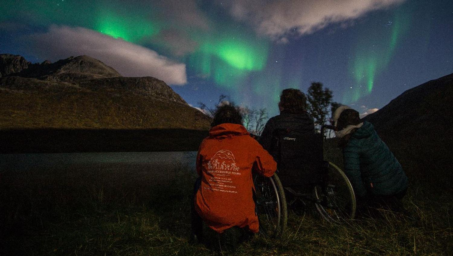 Guests experience the Northern Lights on an accessible guided tour from Tromsø in the Arctic winter landscape.