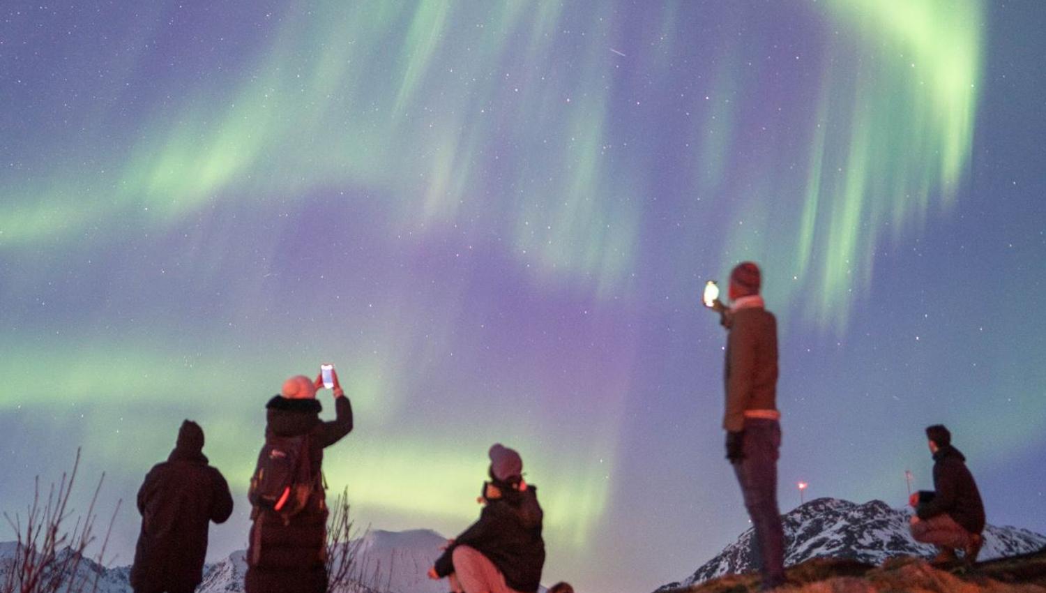 Gjester som ser på nordlyset.