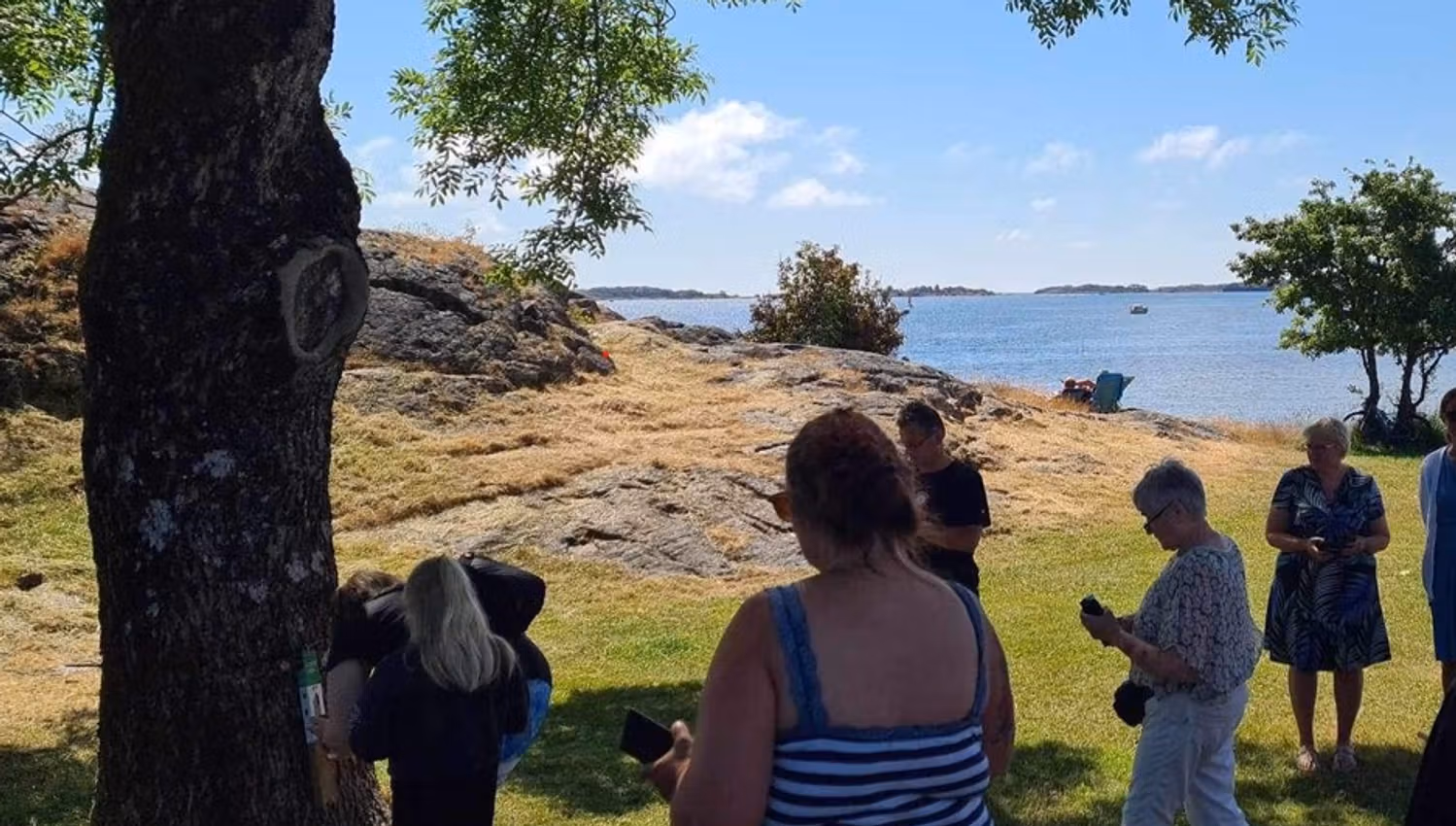 Folk ute i naturen ved siden av stolpen