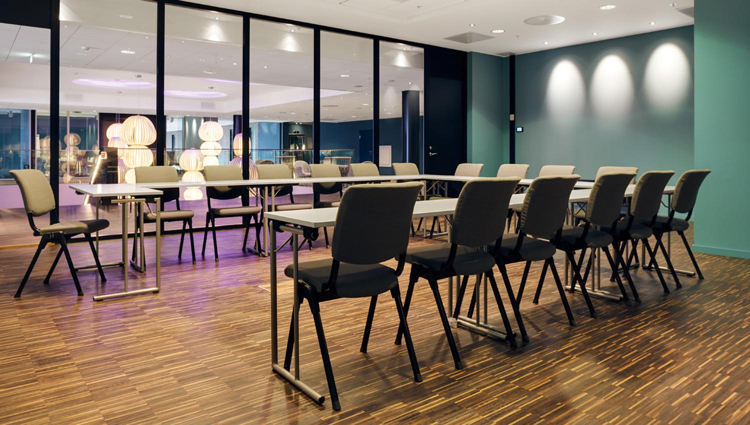conference hall with horseshoe-shaped tables and conference technology