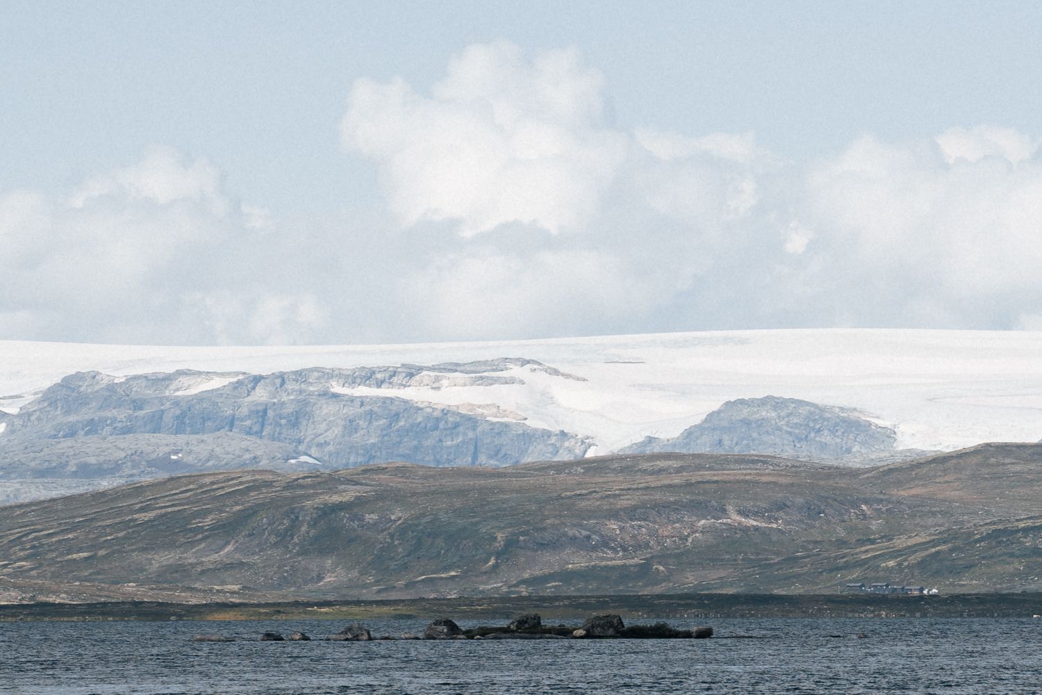 A mountain lake, the Hardanger glacier towering far in the background.