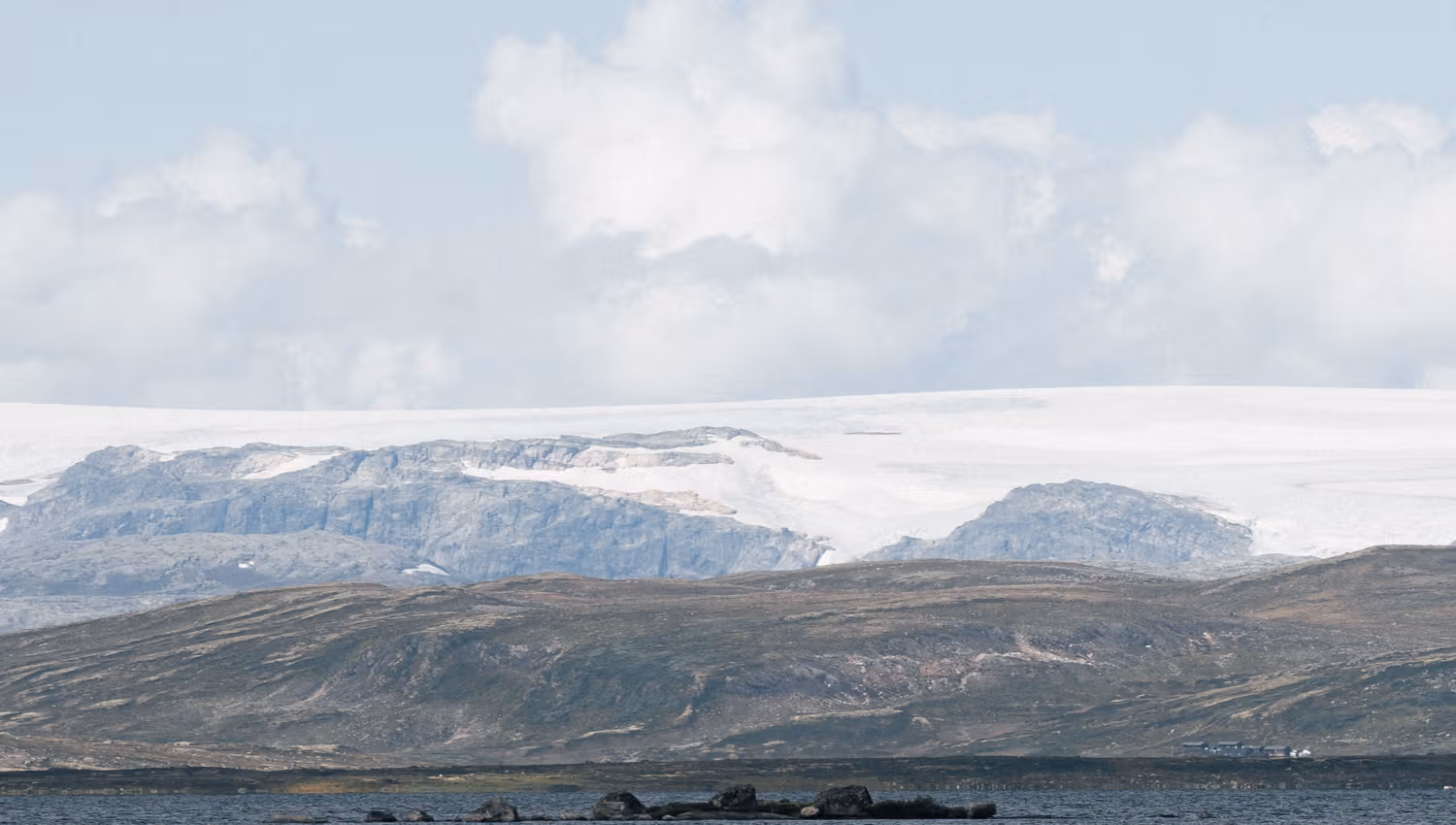 A mountain lake, the Hardanger glacier towering far in the background.
