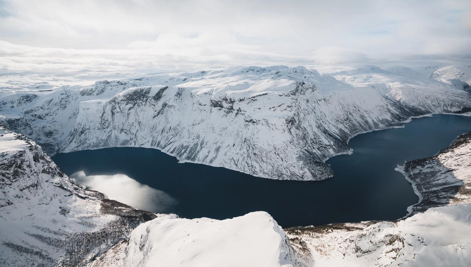 A overview of the Hardangerfjord surrounded by snow-covered mountains.