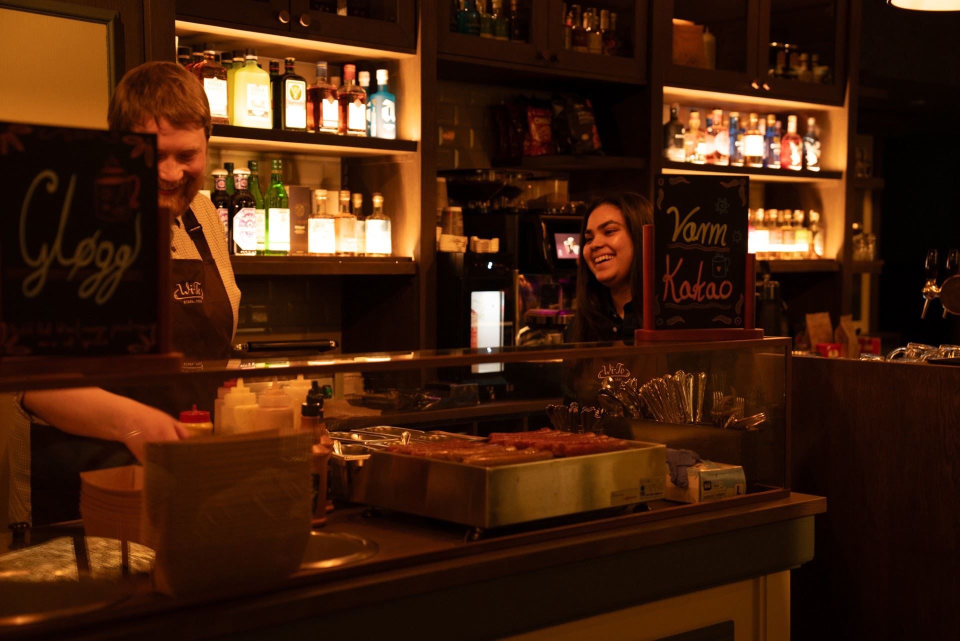 To personer som snakker sammen ved baren