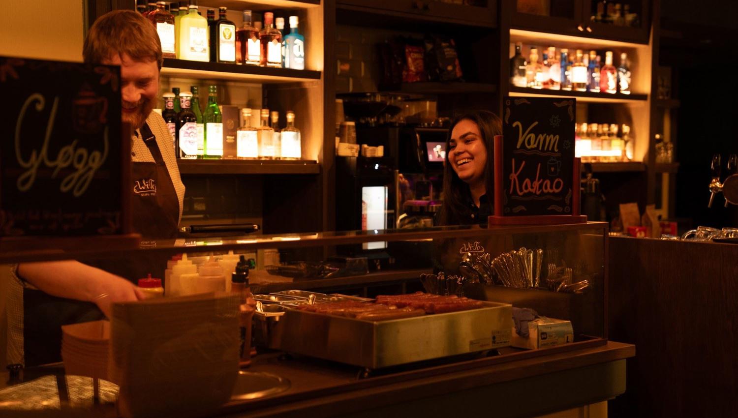 To personer som snakker sammen ved baren
