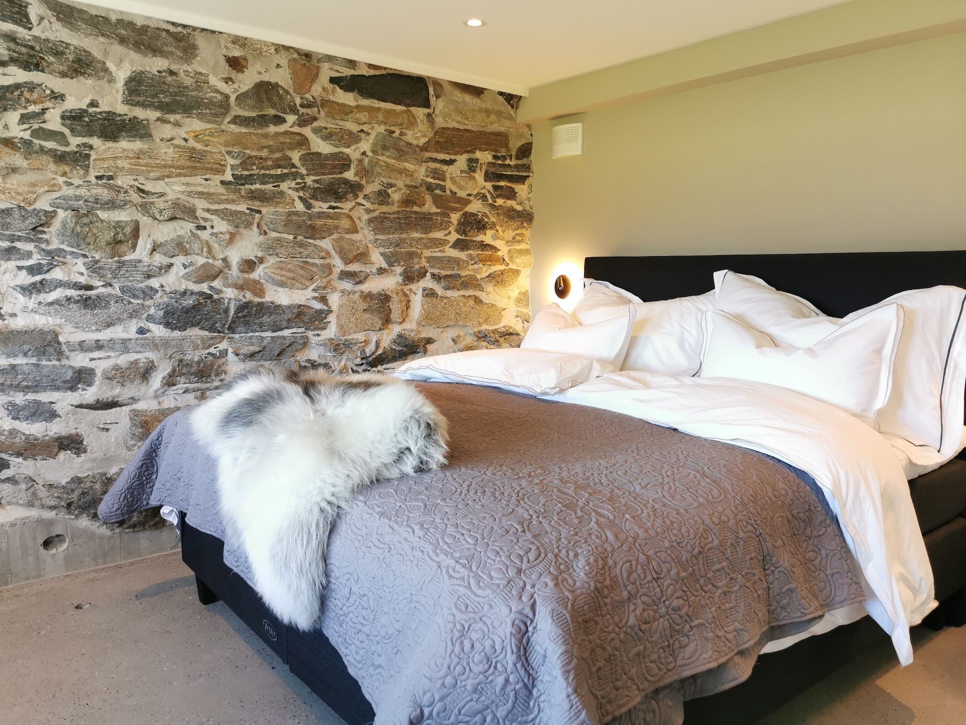 Soverom med steinvegg hos GODØ LODGE