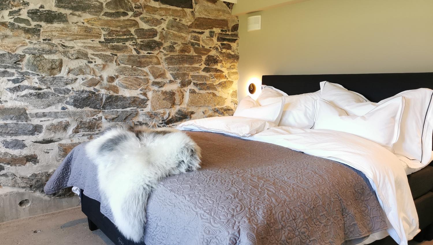 Soverom med steinvegg hos GODØ LODGE