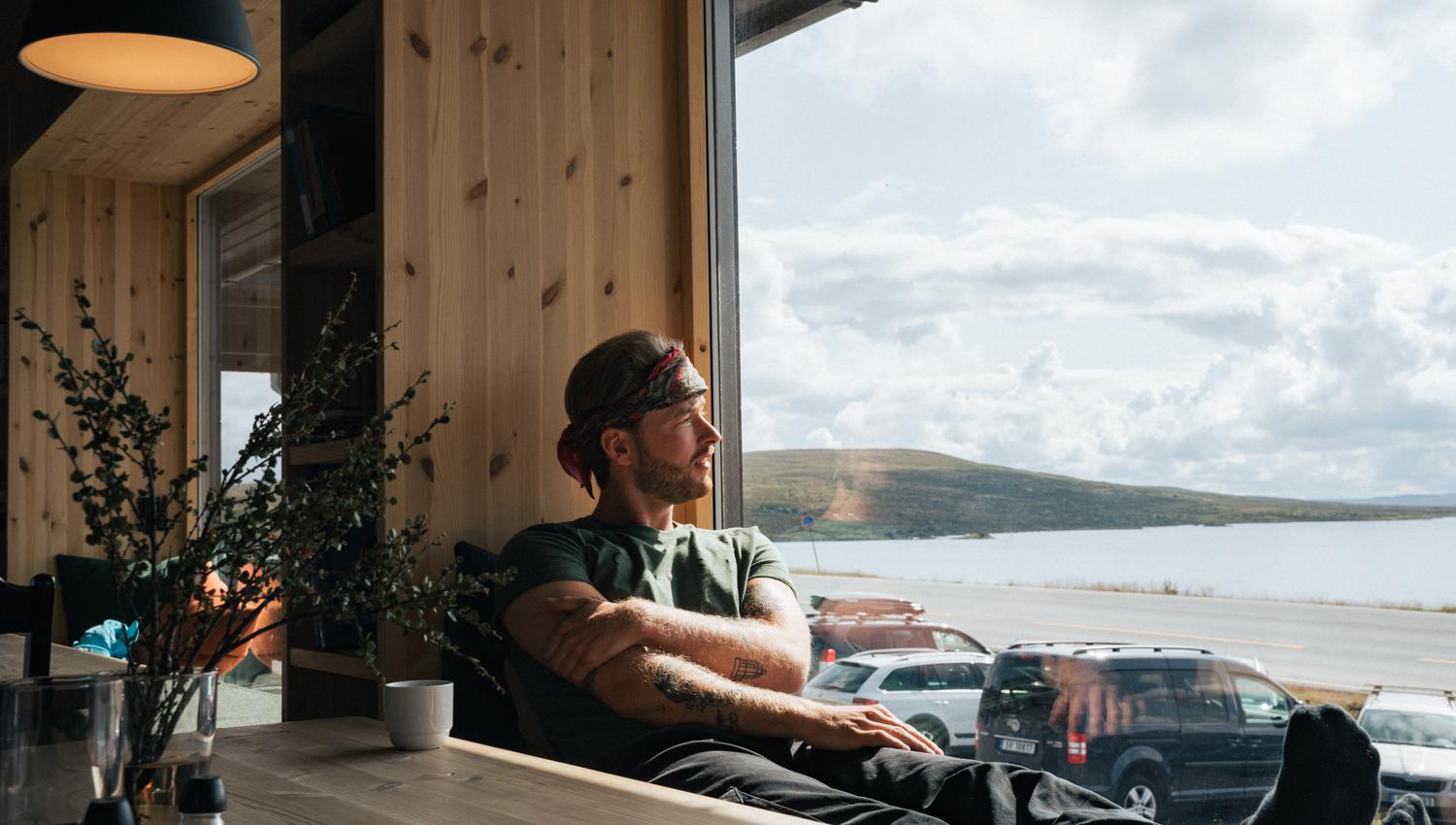 A man relaxing by the window in the restaurant.