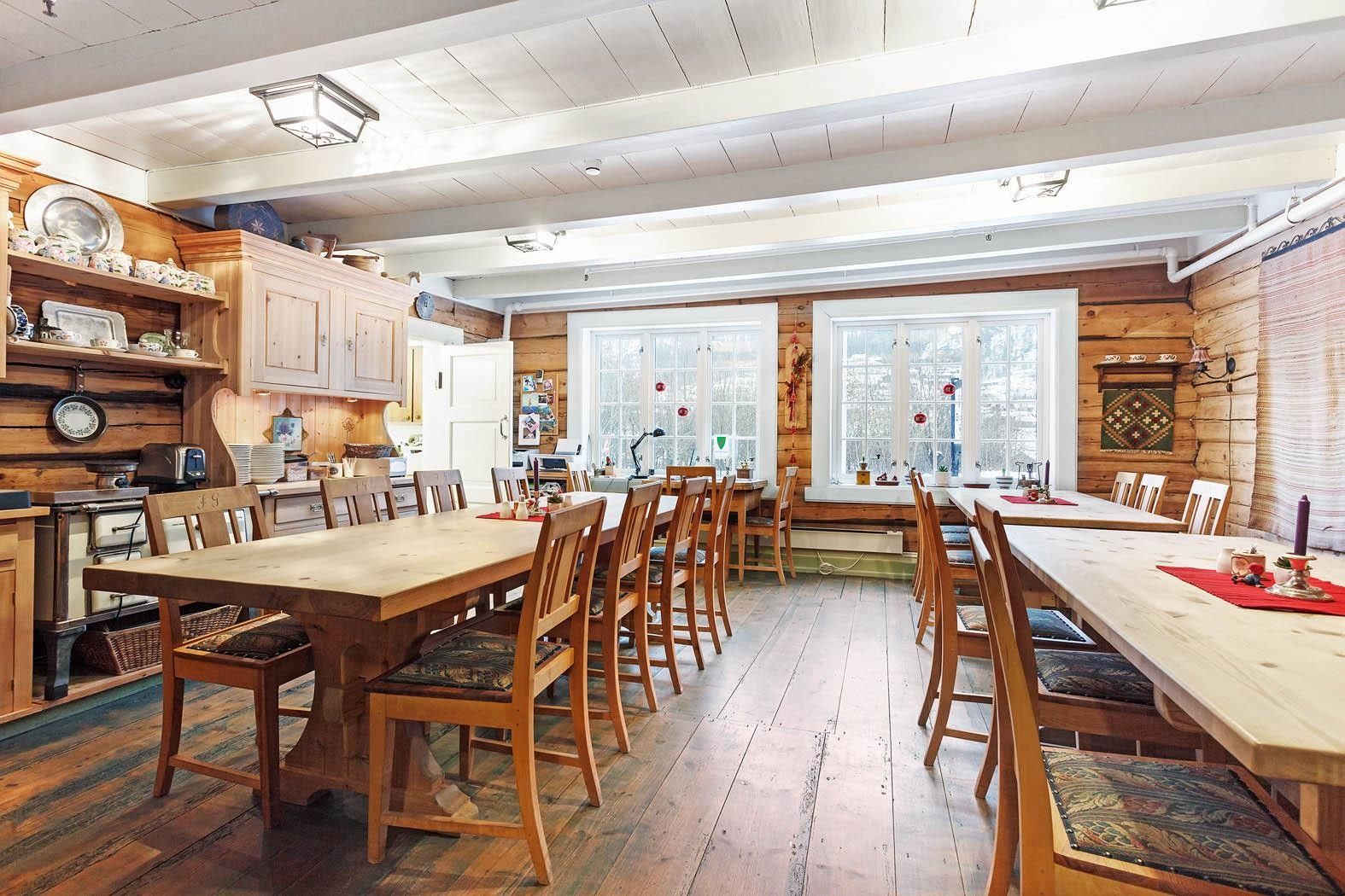 Traditional dining hall with wooden log walls and long tables at Jaunsen Guesthouse in Hardanger.