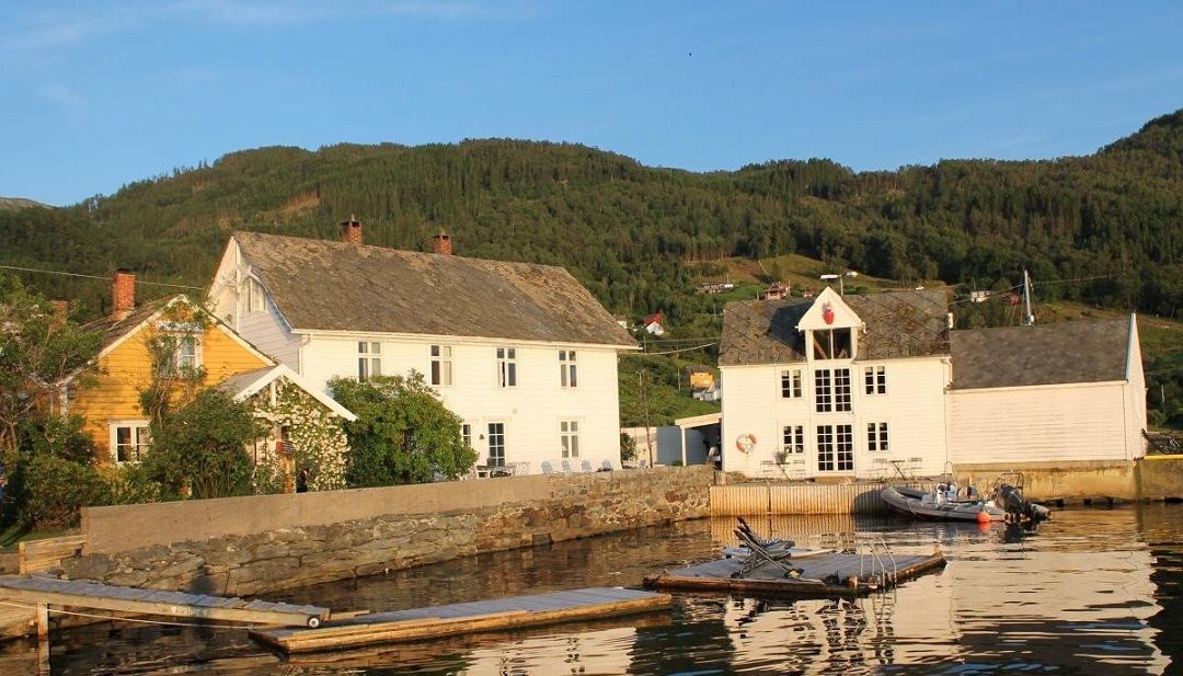 Traditional buildings by the fjord in Herand, Hardanger. Kramsjø is a picturesque guesthouse with stunning views.
